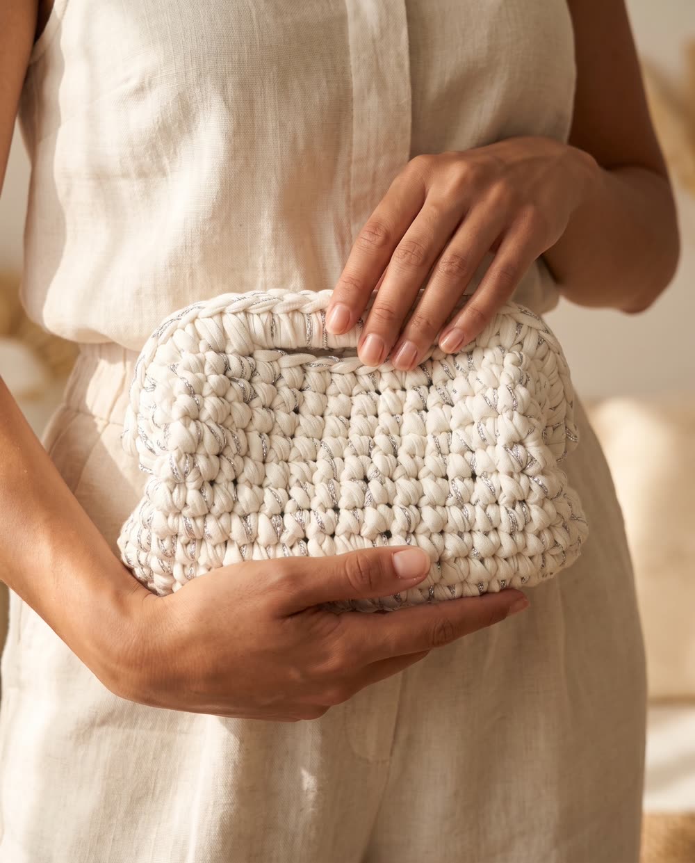 Clutch bianca con filo argento tenuta fra le mani